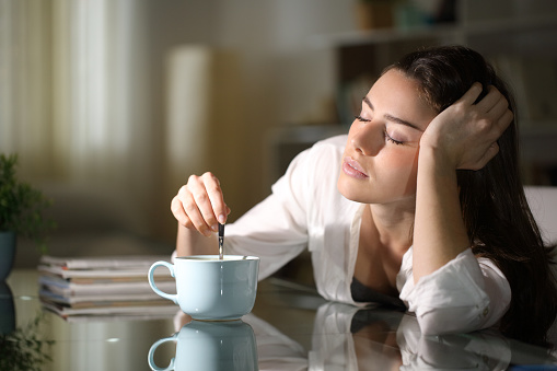 Woman stirring a cup of coffee.